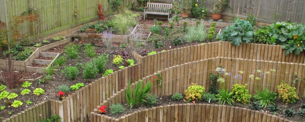 Landscape a slope by extending into the bank and build a strong wall as low as possible Create a series of low terraces and a path that winds through the area